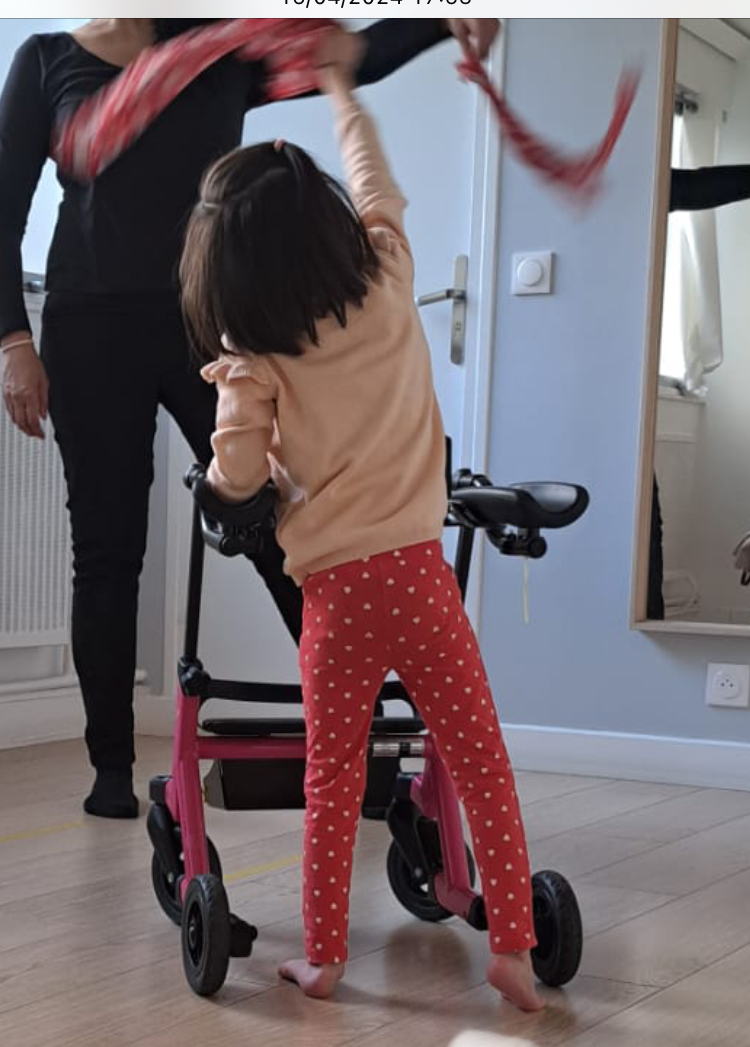 Enfant en situation de handicap moteur dansant avec un ruban lors d'une séance de danse adaptée