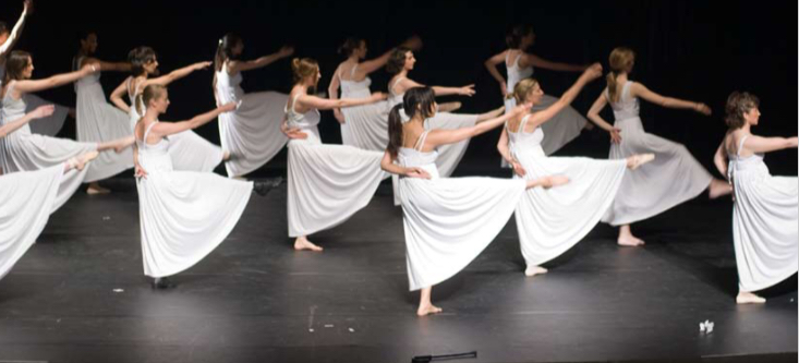 Élèves adultes en robes blanches, chorégraphie modern jazz sur scène