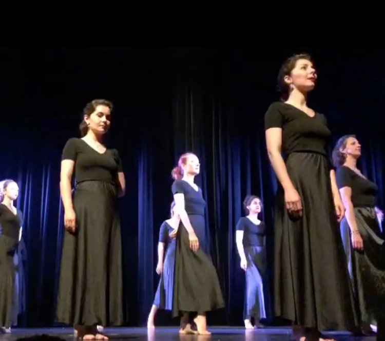 Élèves du cours de danse adultes de Mishell sur scène, en jupes longues noires